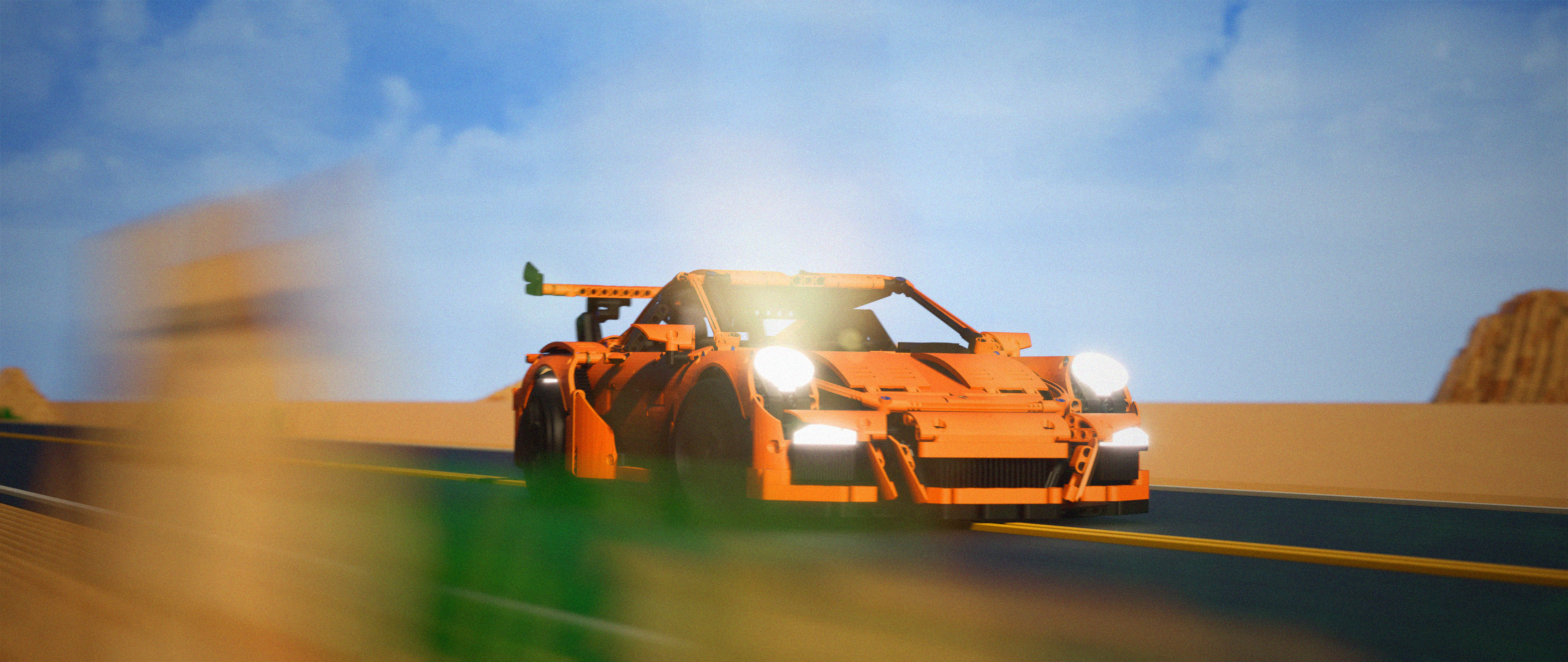 3D visualization of a orange Lego Technic sports car speeding on a desert road.