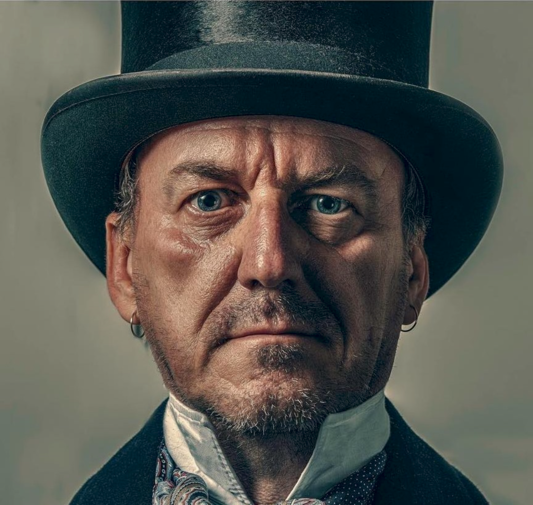 Portrait of Craig Hodge in a Top Hat. Wearing a blue Paisley patterned cravat
