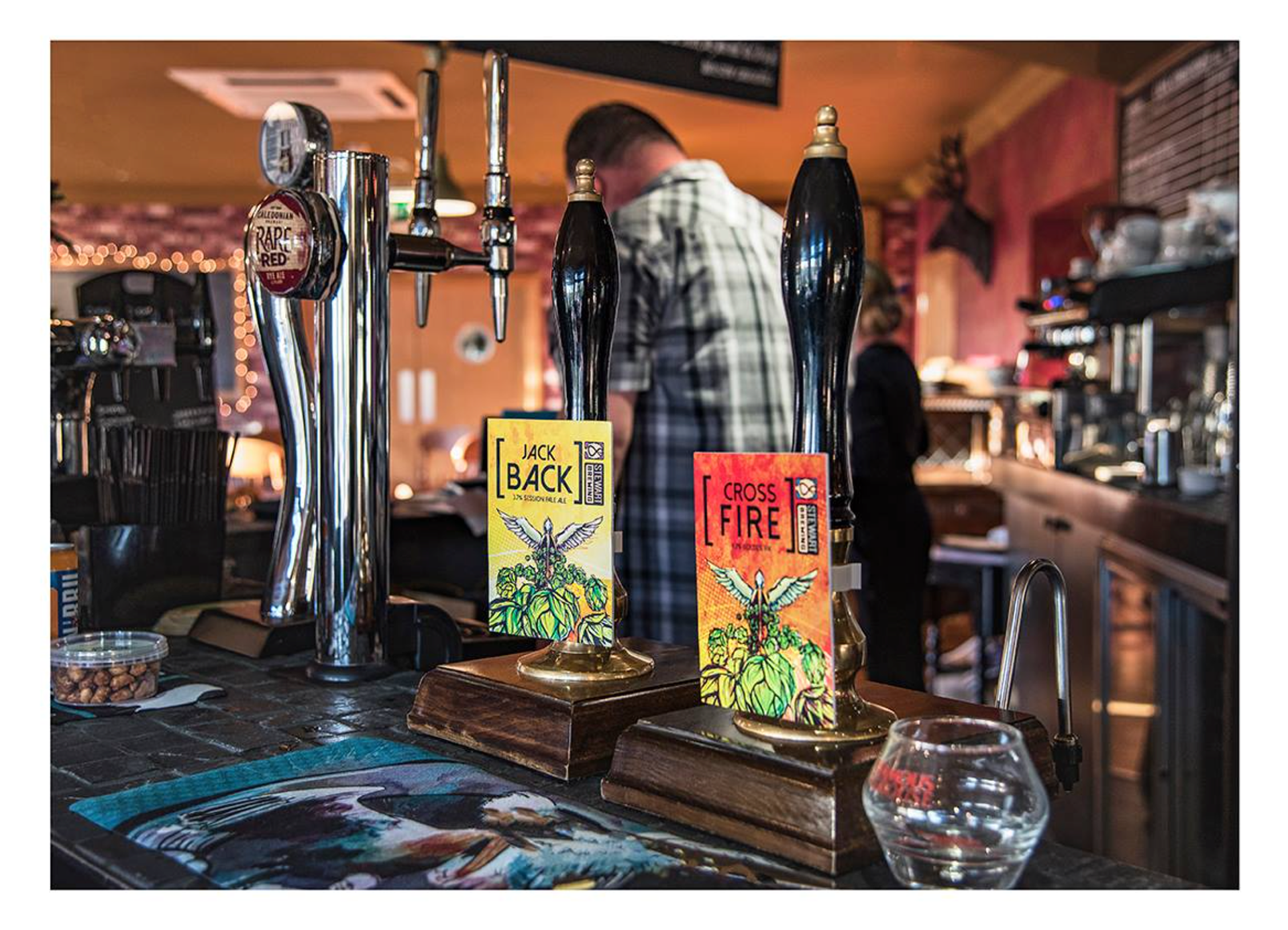 Photograph showing the pumps in the bar of the Leadburn inn. With a barman in the background slightly out of focus
