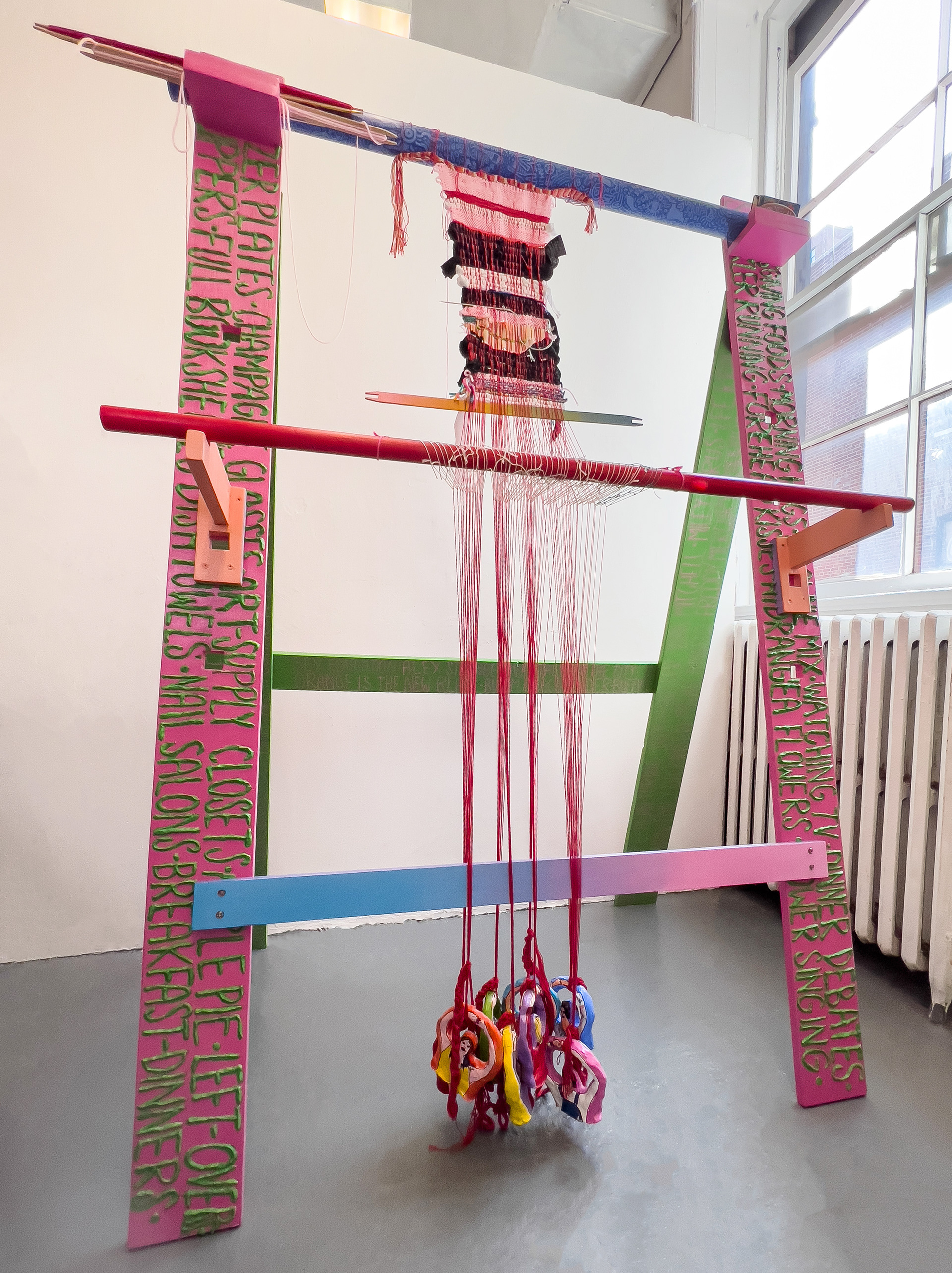 Front of Warp-Weighted Loom. 2021, ongoing. 69 in. x 48 in. x 34.5 in. Wood, acrylic paint, air-dry clay, model magic, thread, heat-sensitive pigment, stickers, paper, screws, nails, and glitter.