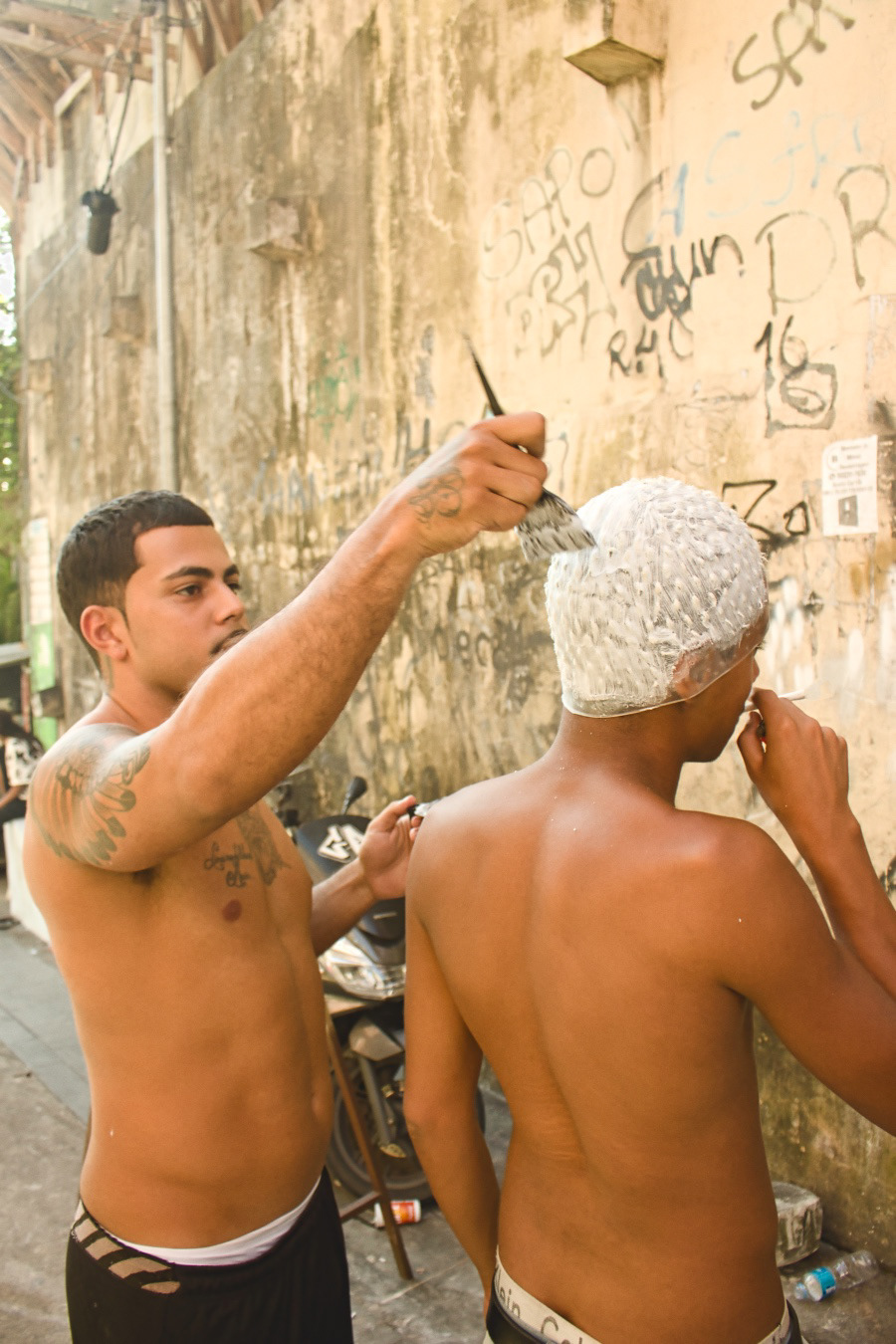 Reflexo de Verão - O Artista e Cabeleireiro Piu fazendo reflexo no seu cliente fora do salão - no verão os salões da favela costumam ficar muito cheios por causa da grande demanda.