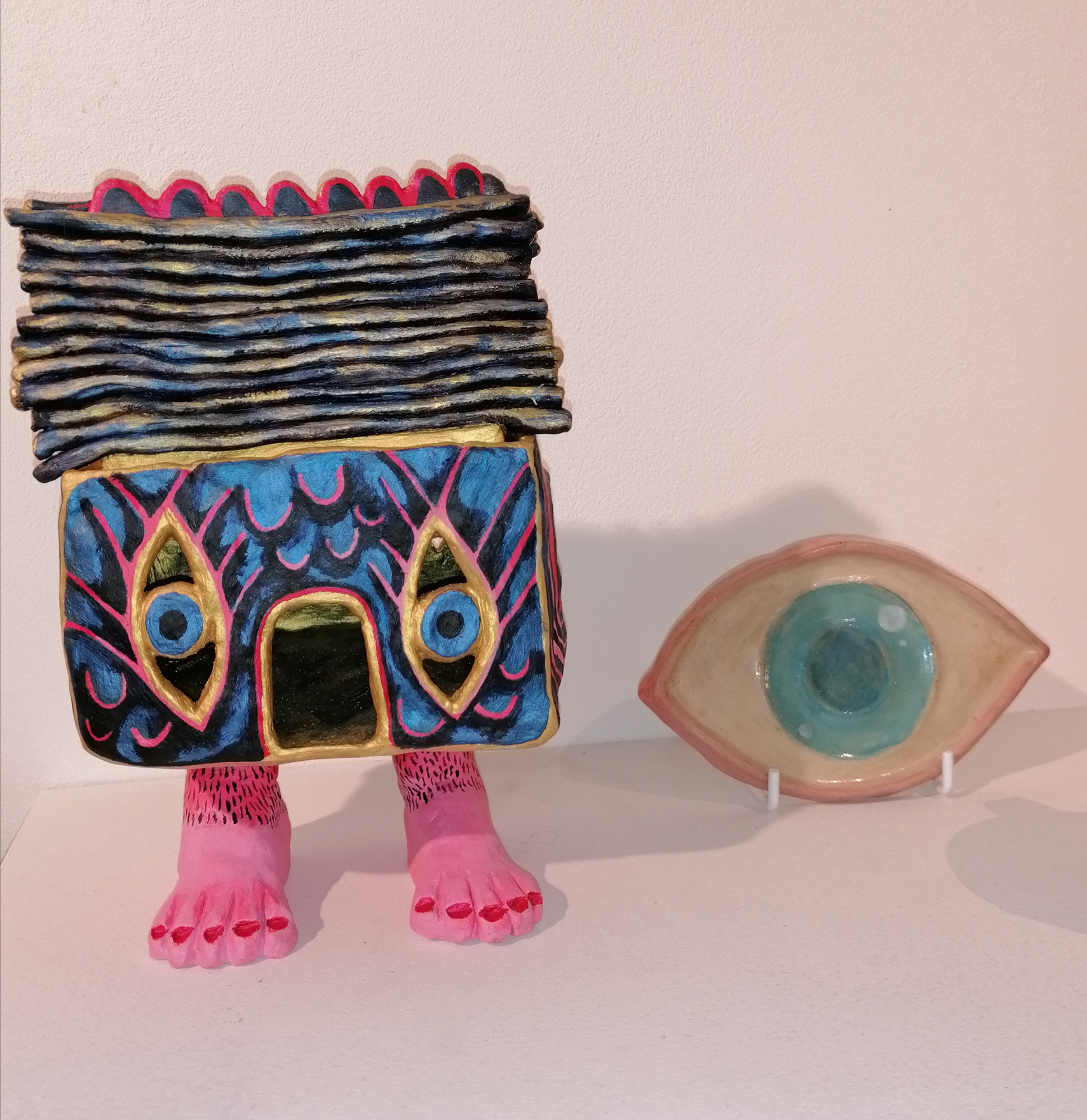 Baba Yaga house alongside an eye teacup coaster made by another artist.