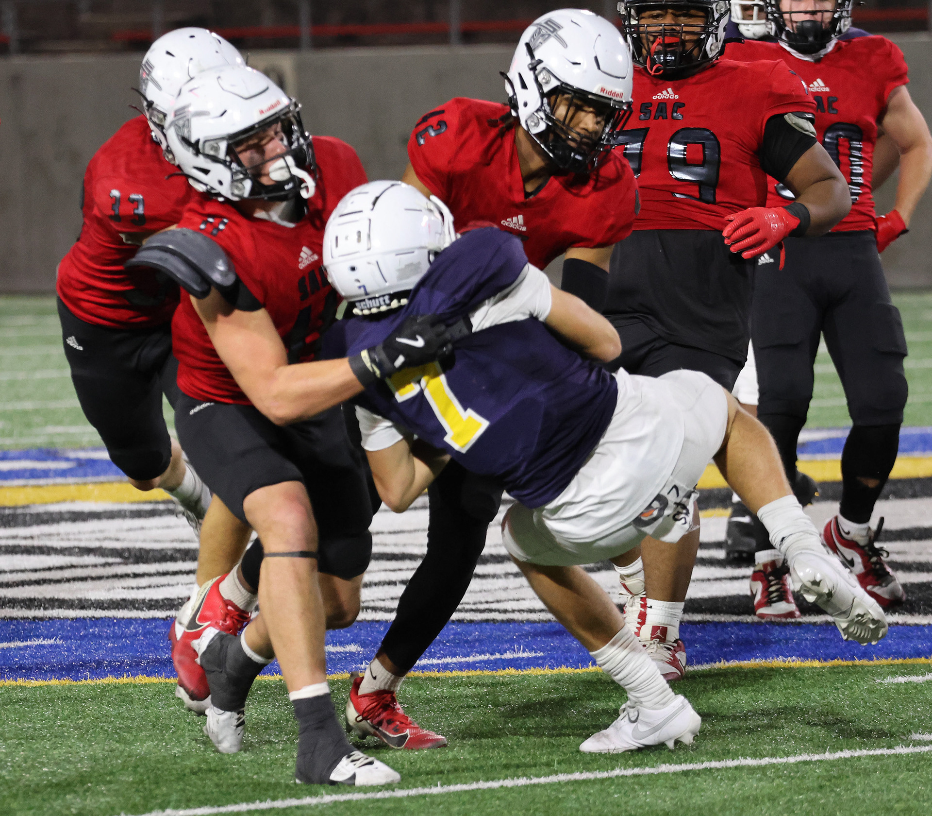 Zamir Richardson and Owen Tesch are pictured tackling a ball carrier in the backfield.