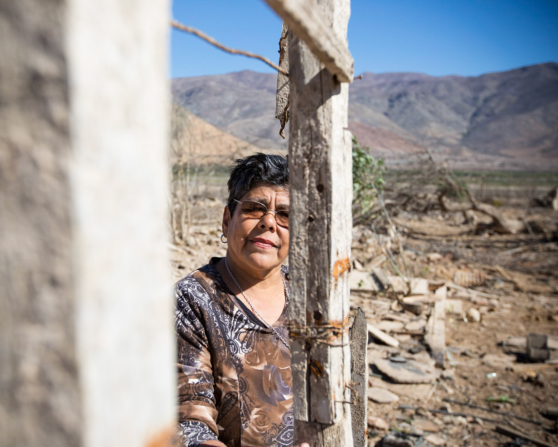 Gualliguaica, Chile. The original village of Gualliguaica, where Natalia Edith Codoceo Flores lived until the 1990s,  was flooded when the Puclaro Dam was built. But the long lasting drought has diminished the reservoir to 10% (or less) of it's capacity. The entire old village is now exposed, as the "reservoir" essentially receded back to the original bed of the Elqui. She stands inside an old door frame of a once-submerged house. Taken April 29. 2013.