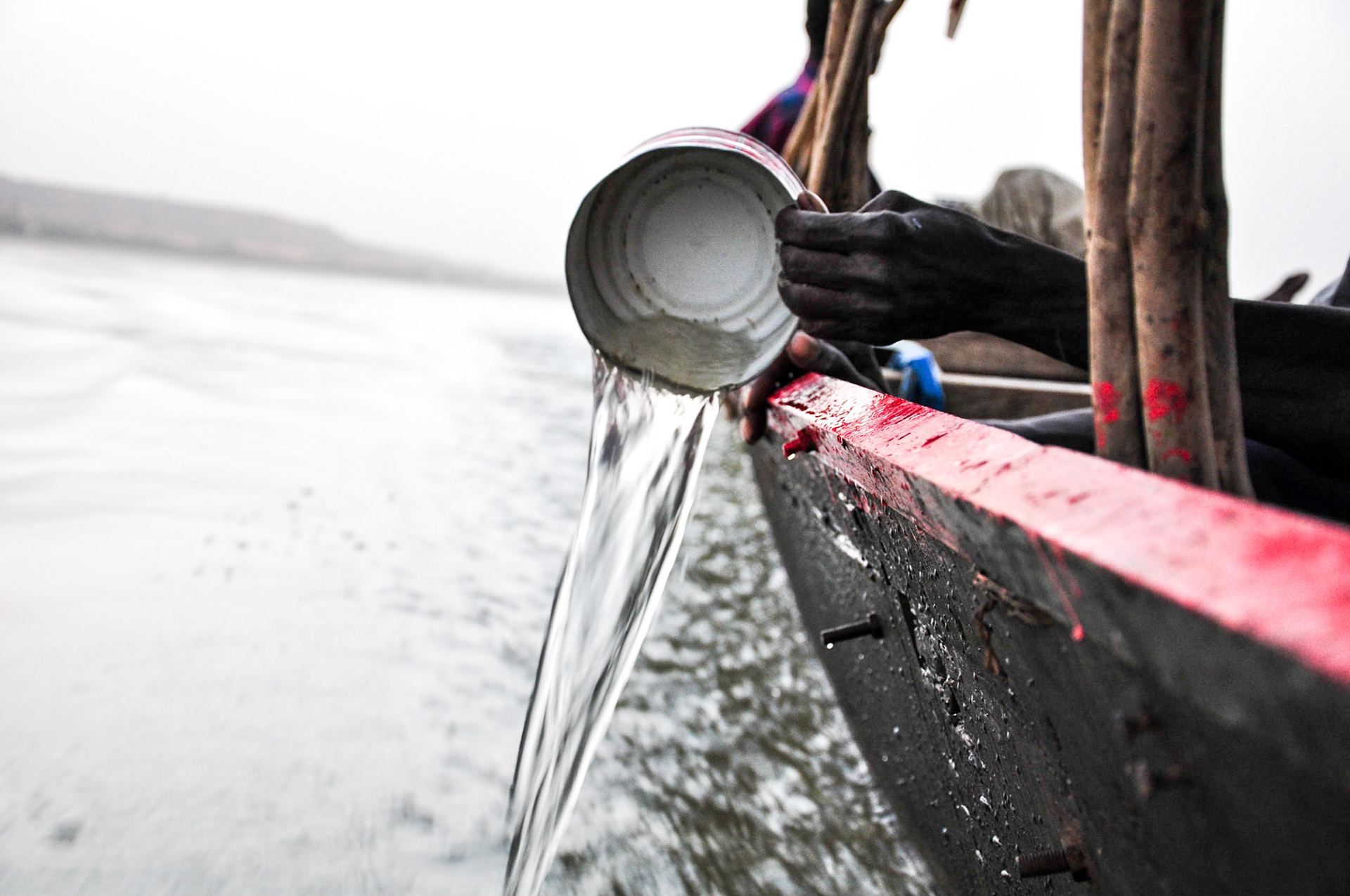 Niamey, Niger. Bailing water from a long boat during a cruise on the Niger River. Taken February 16, 2011.