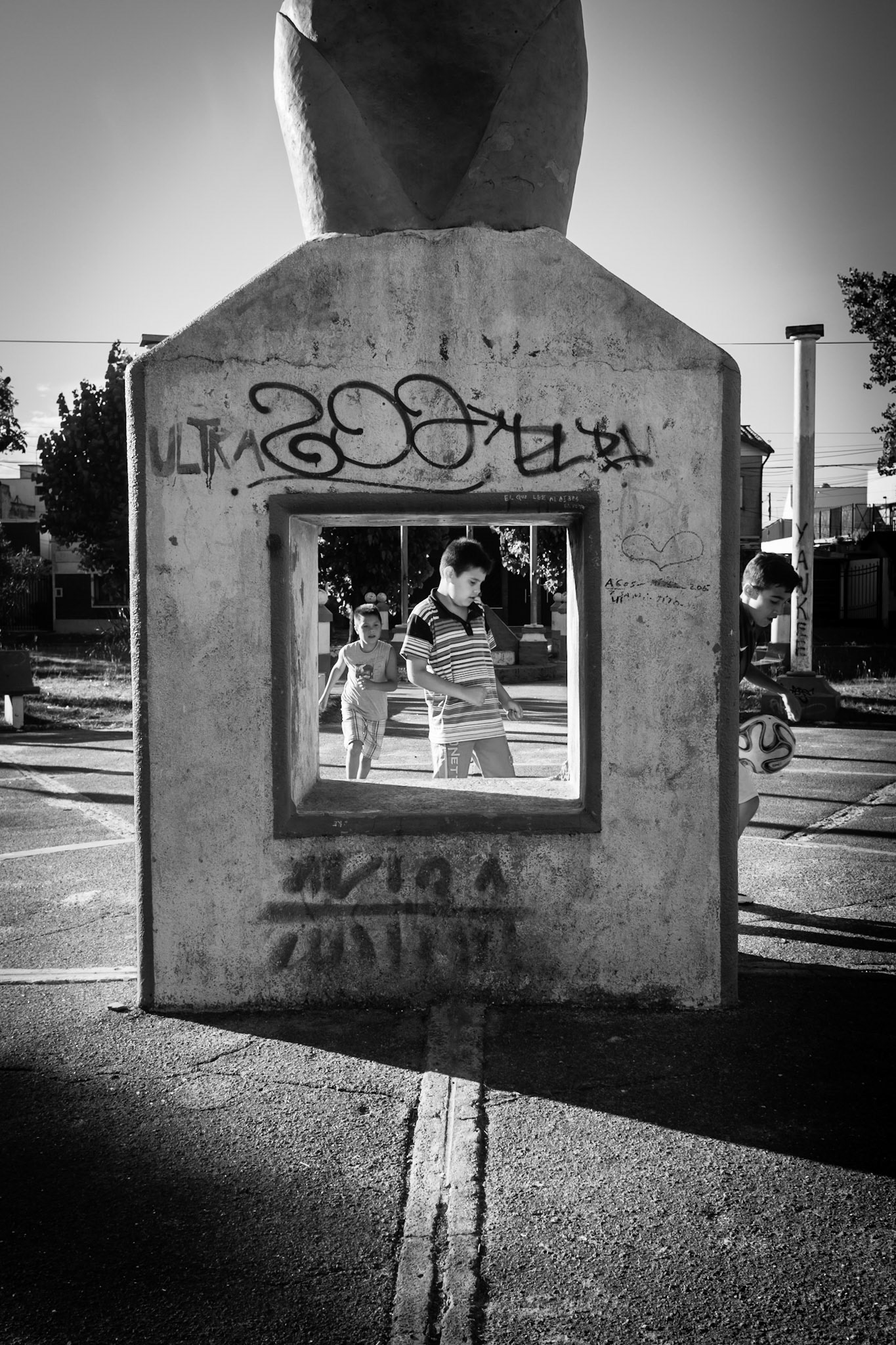 Children play a soccer game in a paved park outside of Buenos Aires.