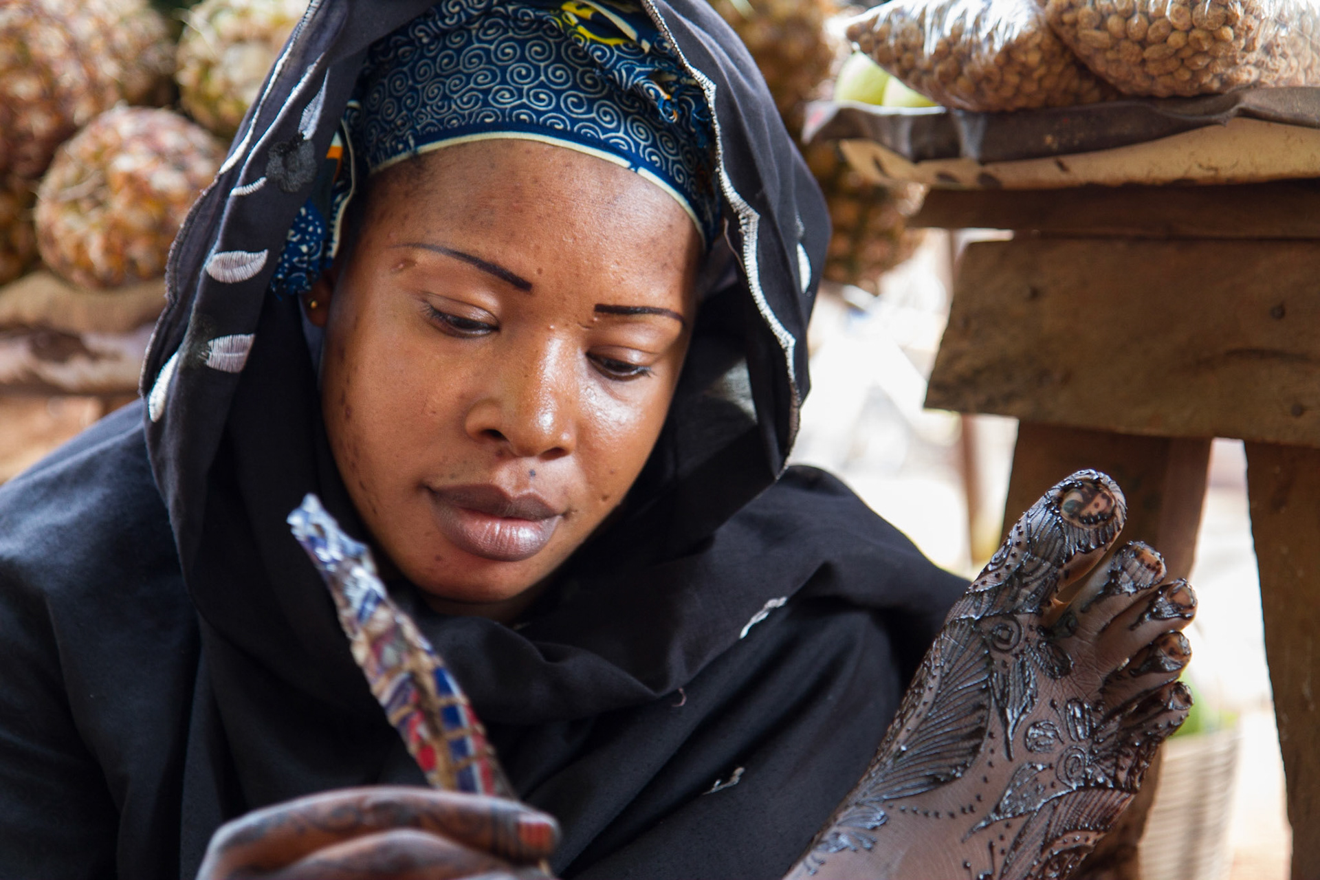 Sikasso, Mali. A woman paints henna designs on a client's feet. Taken July 3, 2012.