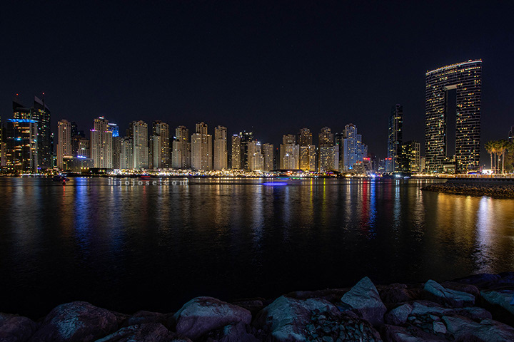 Dubai Marina skyline reflecting on calm waters at night