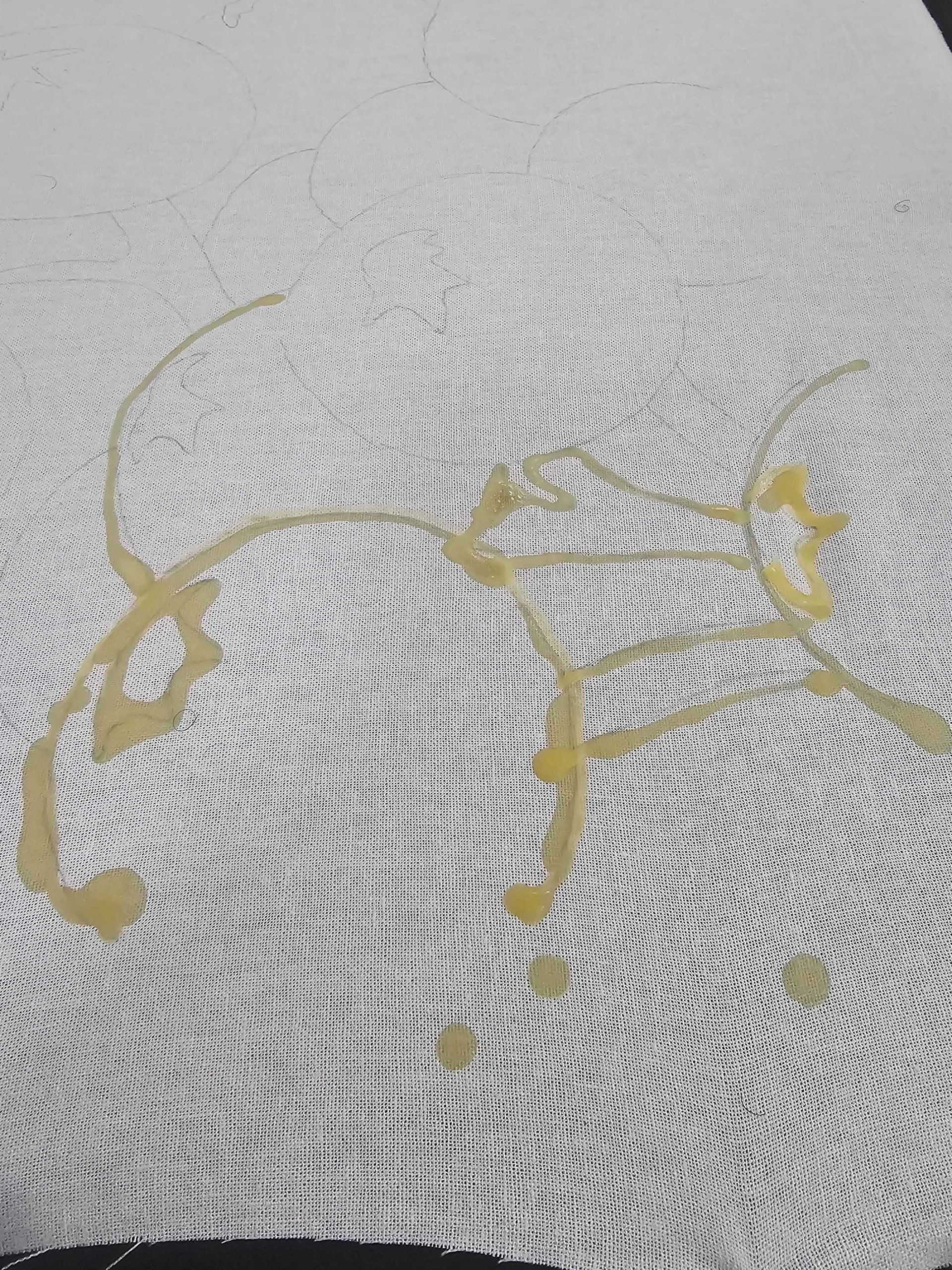 a close up of Beeswax being applied to stretched cotton