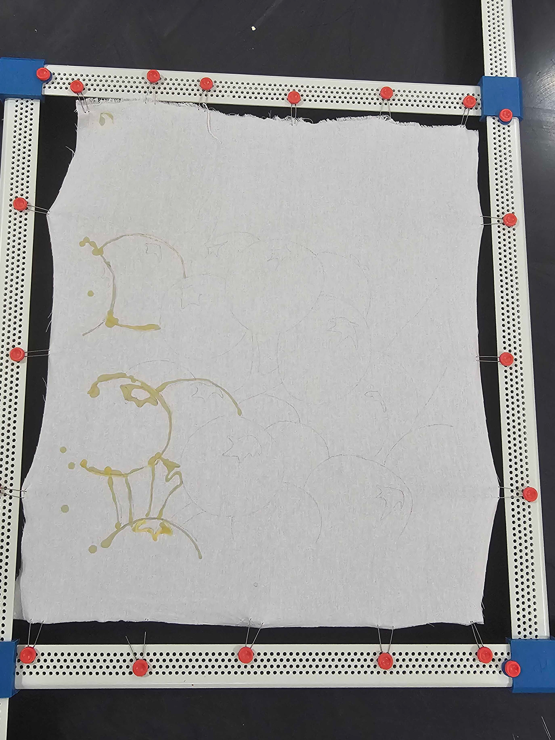 Beeswax being applied to stretched cotton