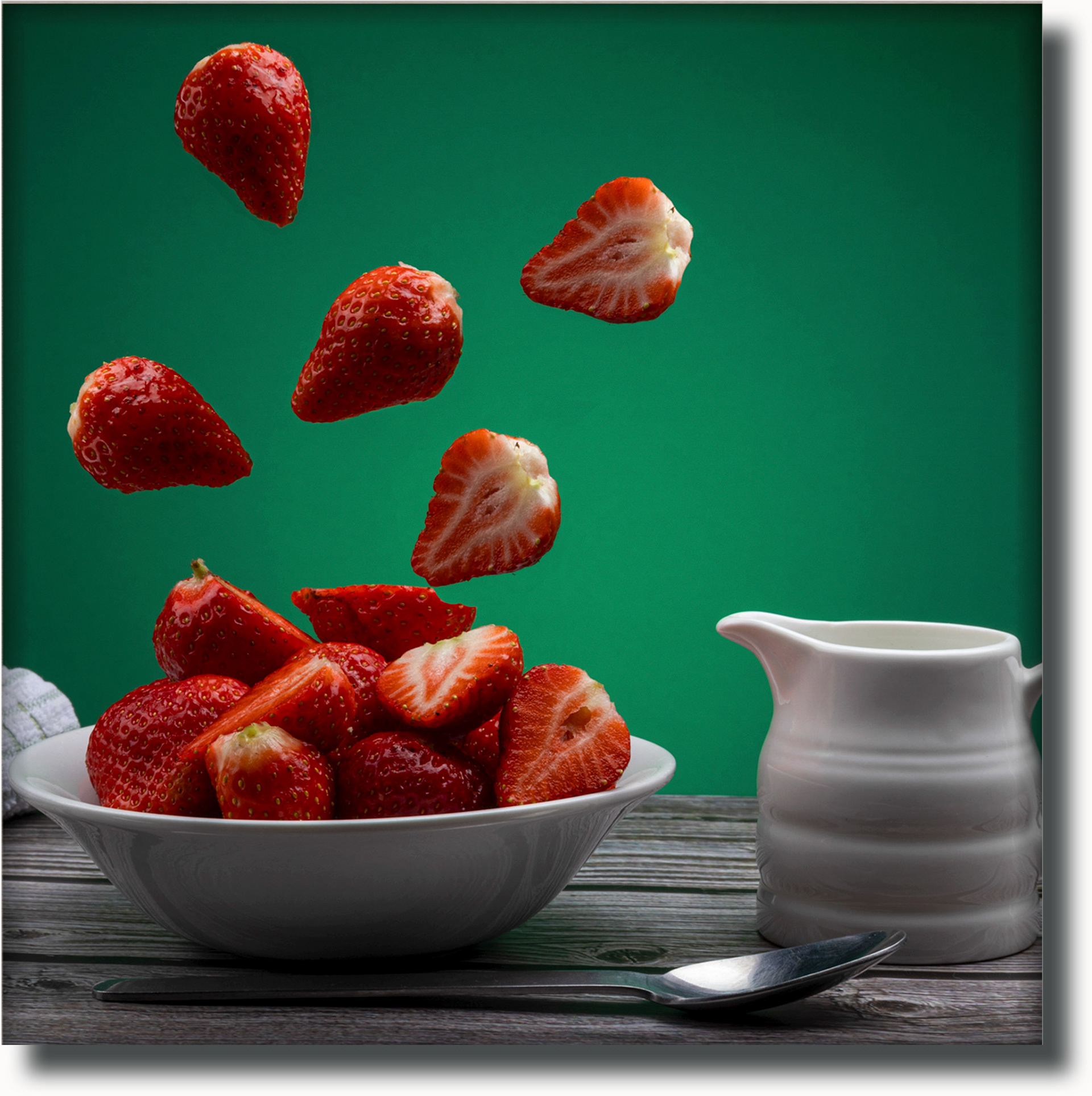 strawberries falling into a bowl