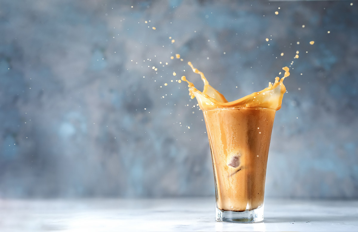 Iced latte caught in motion – coffee photography with dynamic flair