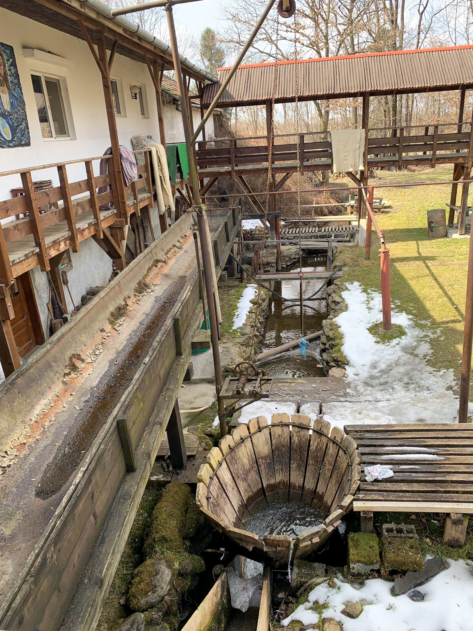 The "bucket" you see is the whirlpool, where water falls on th rugs. The rugs are then lifted and left to dry.