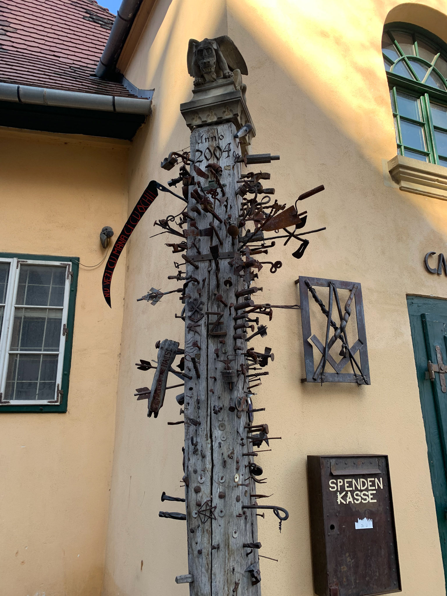 A hostel for people who have picked up apprenticeship in trades (blacksmith etc). The things nailed to the post are said to be what was done for their "final" exam, promoting from apprentice to Journeymen.