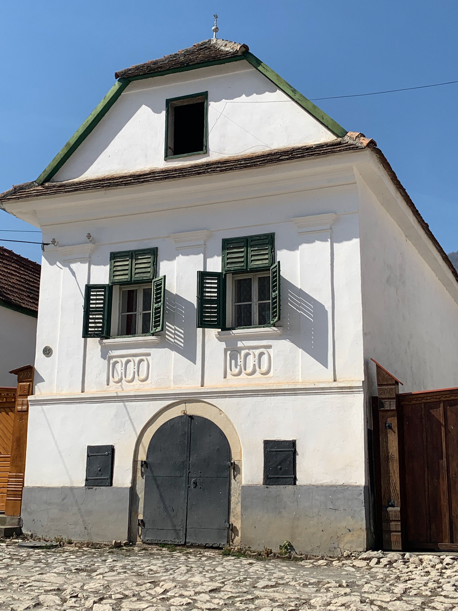 Design of a traditional house in Rimetea. Note the green wood window shutters.