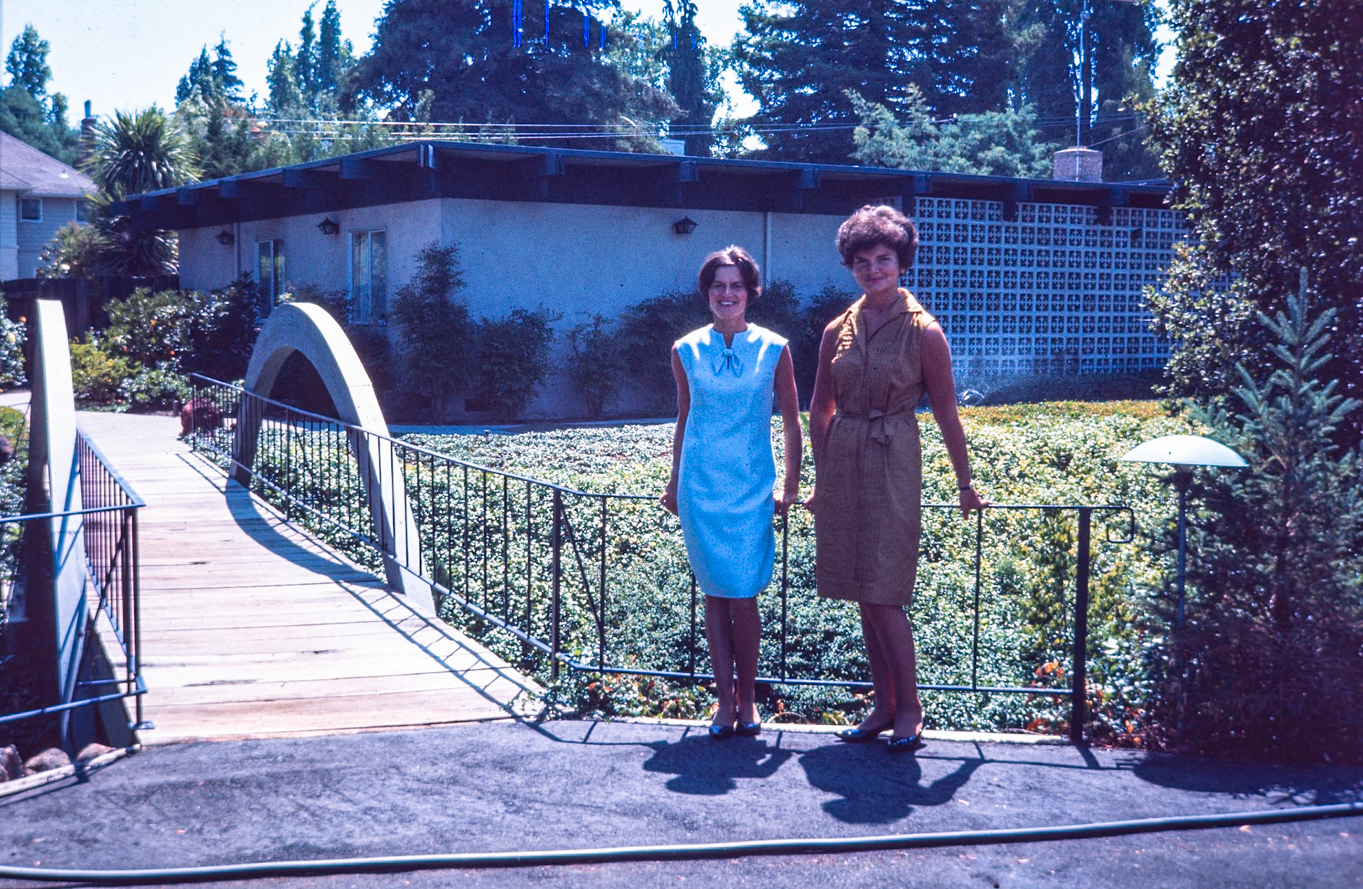 Marthe and Agnes walking across a small pedestrian bridge in France.