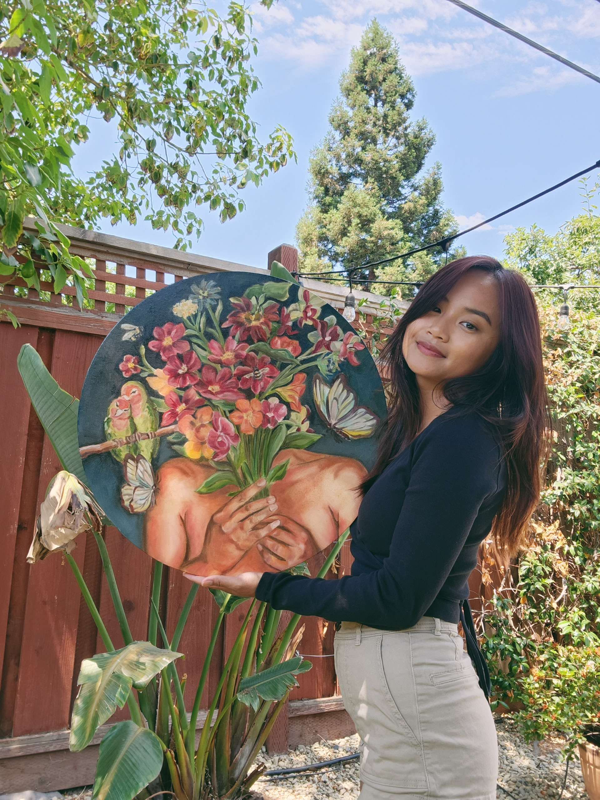 3: Holding finished painting titled "Embrace"