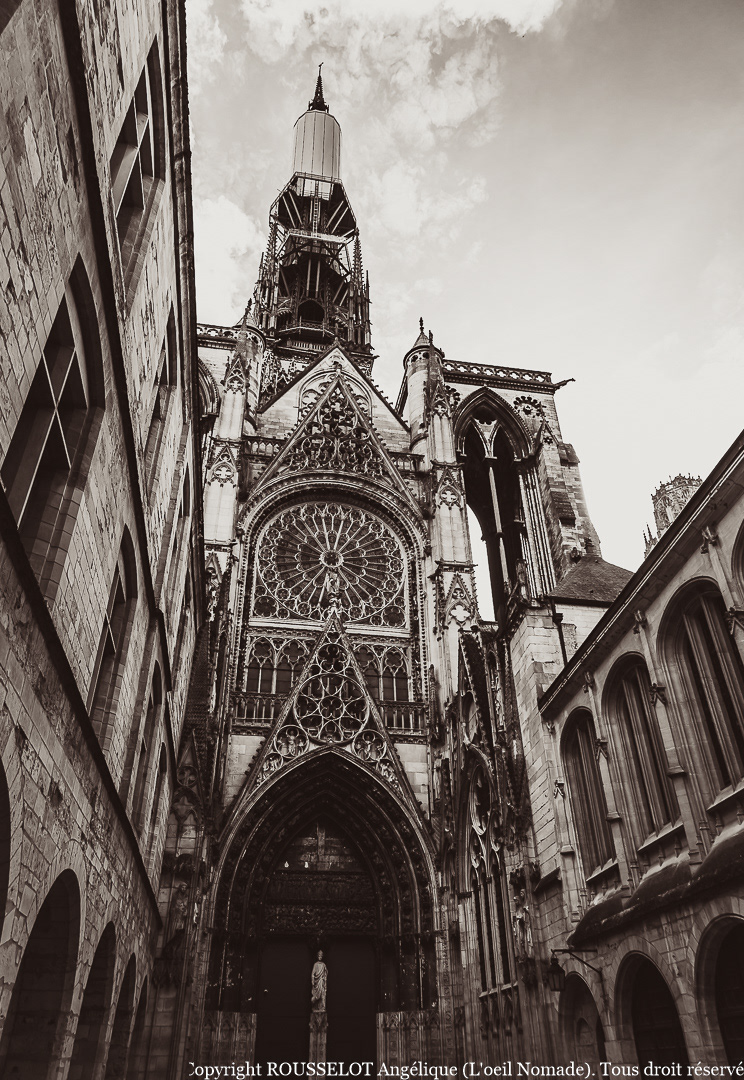 Photographie de la façade gothique de la Cathédrale Notre-Dame de Rouen, vue en contre-plongée mettant en avant sa hauteur monumentale.