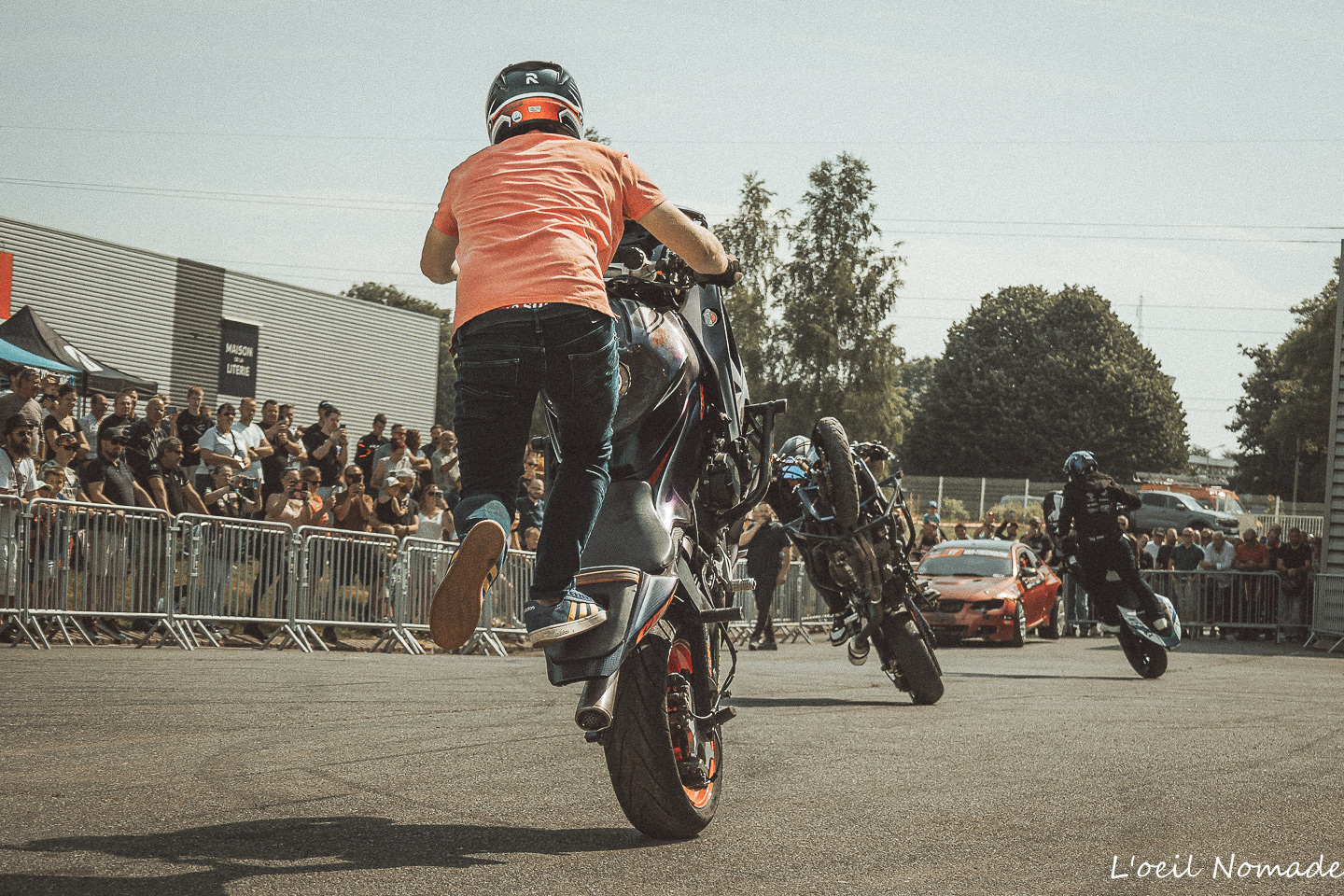 Motard réalisant une figure d'équilibre à basse vitesse lors d'une animation moto.