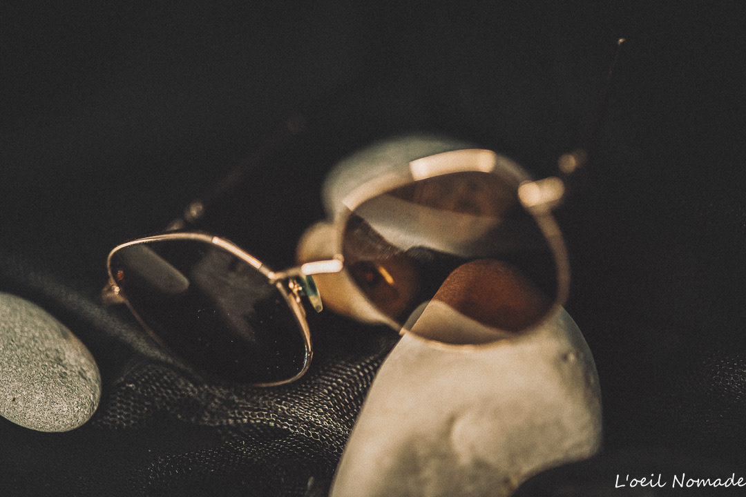 Packshot accessoire de mode : lunettes de soleil vintage posées sur des éléments naturels, photographie lifestyle mettant en avant le design et les reflets.