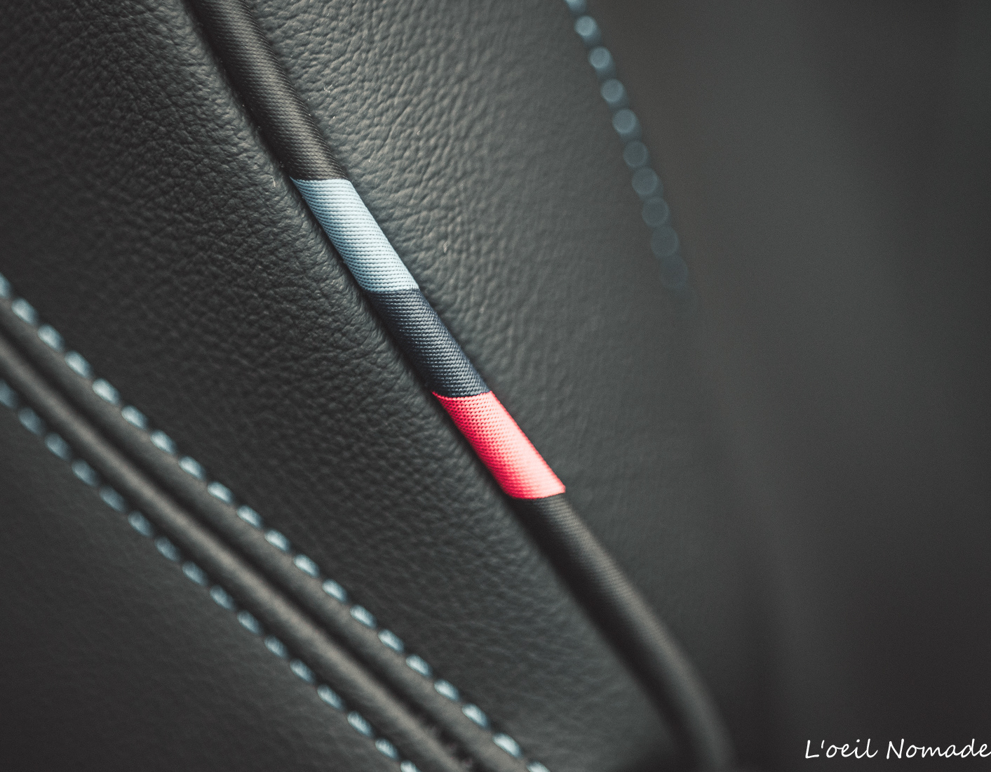 Couture technique M-performance sur cuir intérieur automobile BMW, focus sur l'excellence et le luxe.