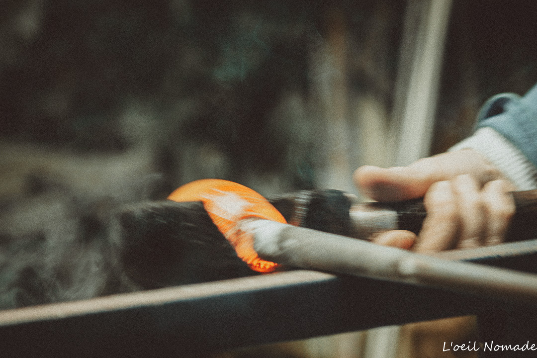 Photographe métier au Havre : gros plan sur le travail d'une souffleuse de verre manipulant une pièce en fusion incandescente avec ses outils en atelier.
