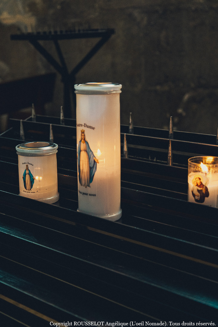 Ambiance et recueillement : gros plan sur des bougies votives à l'intérieur de la cathédrale du Havre.