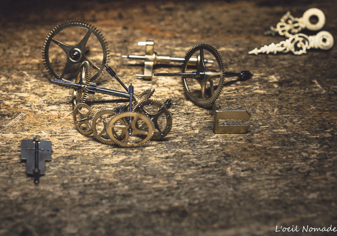 Photographie macro de pièces d'horlogerie, focus sur les textures métalliques et la mécanique de précision, style industriel et documentaire.