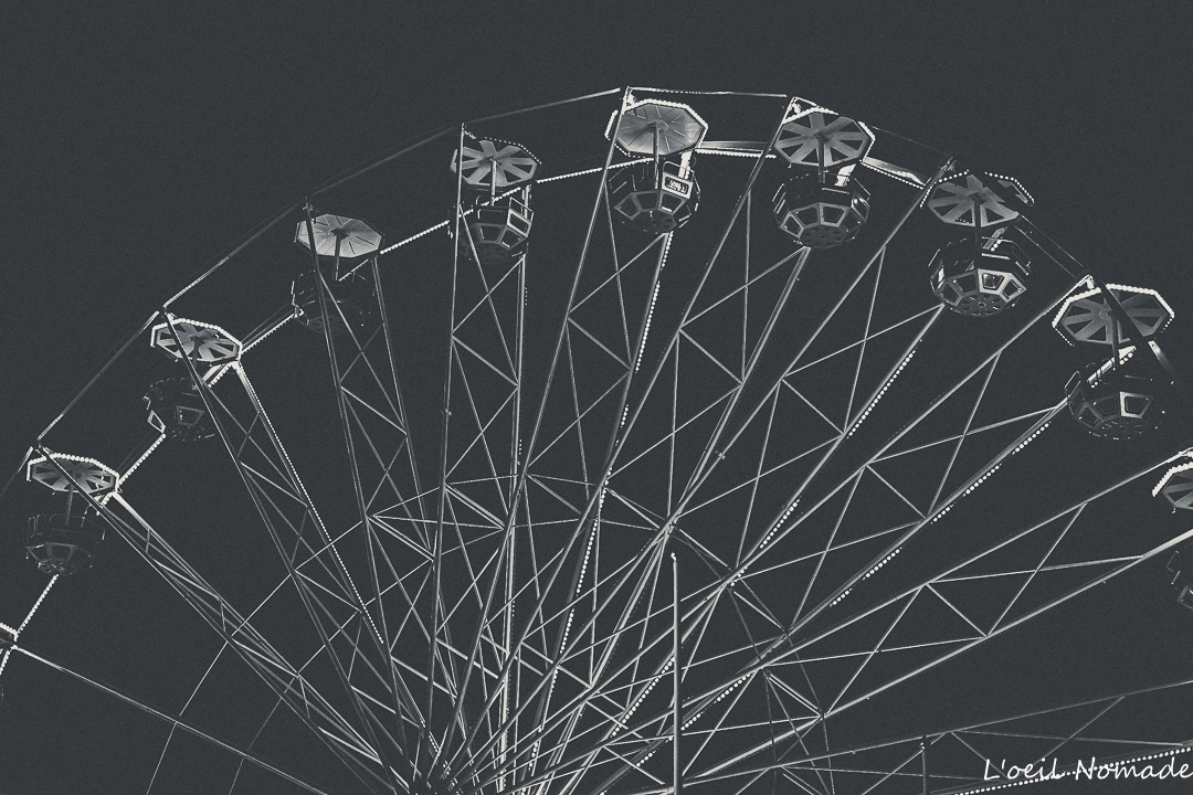 Photographie artistique de la grande roue au Havre : une perspective graphique en noir et blanc pour sublimer le patrimoine festif urbain.