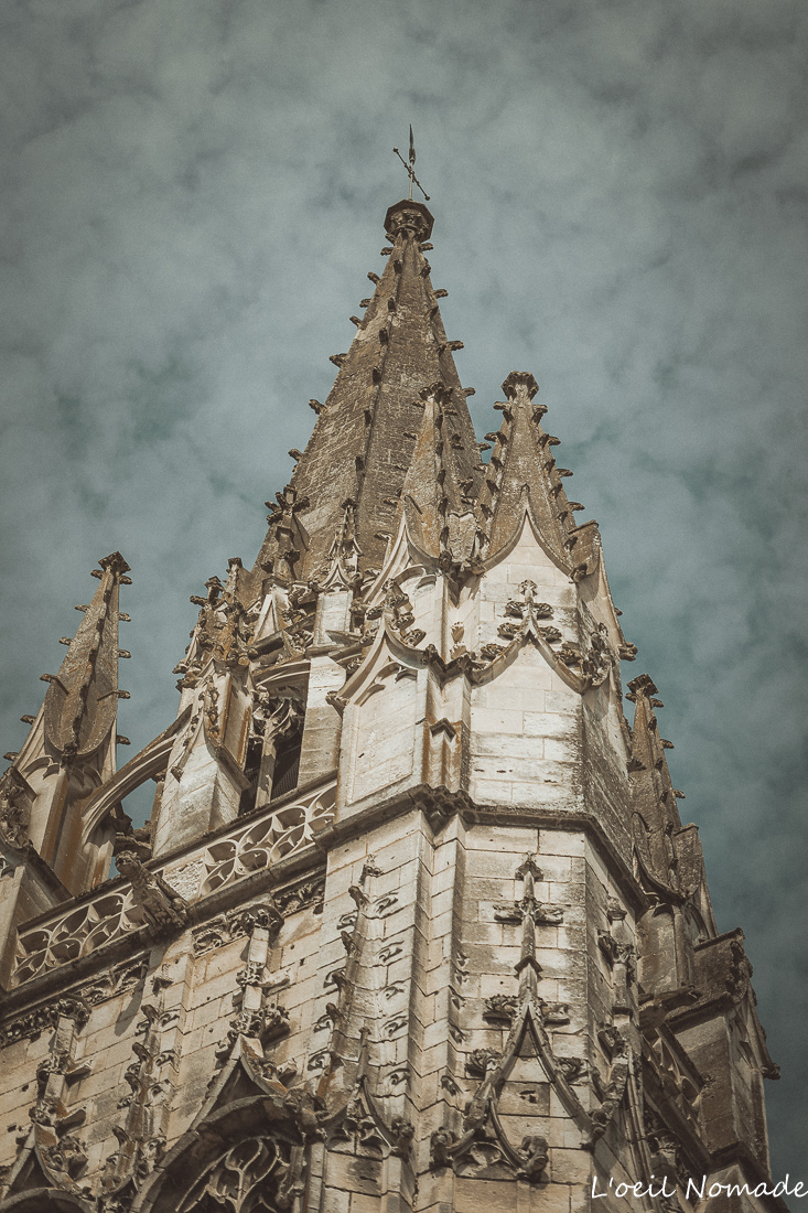 Façade de l’église Notre-Dame de Lillebonne photographiée en contre-plongée mettant en valeur la flèche gothique du monument.