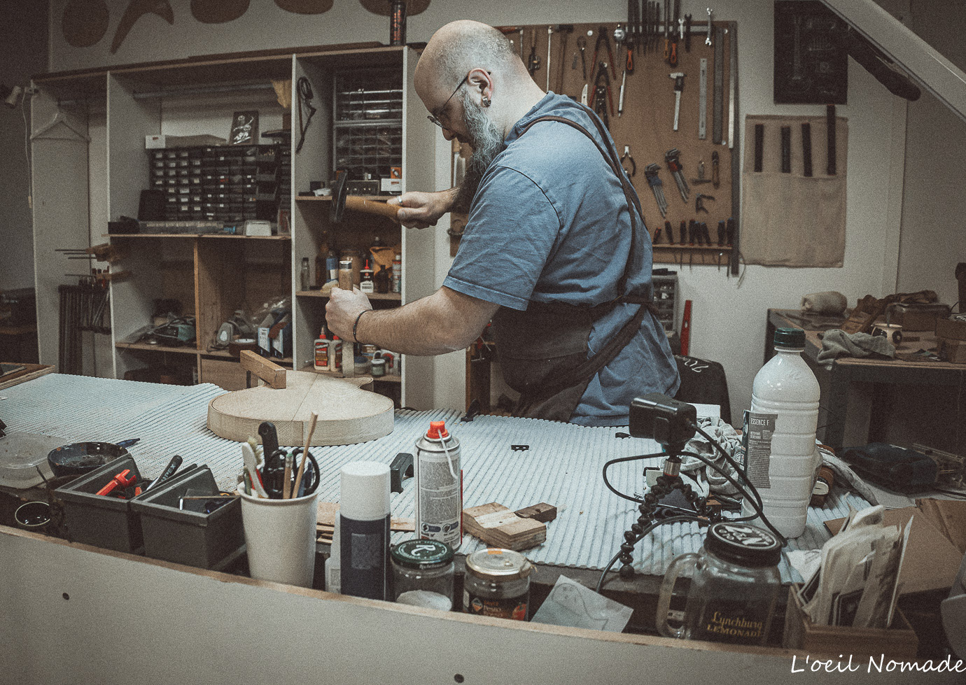 Atelier de lutherie Wooden Owl, outils traditionnels et guitares en cours de fabrication, photographie documentaire.
