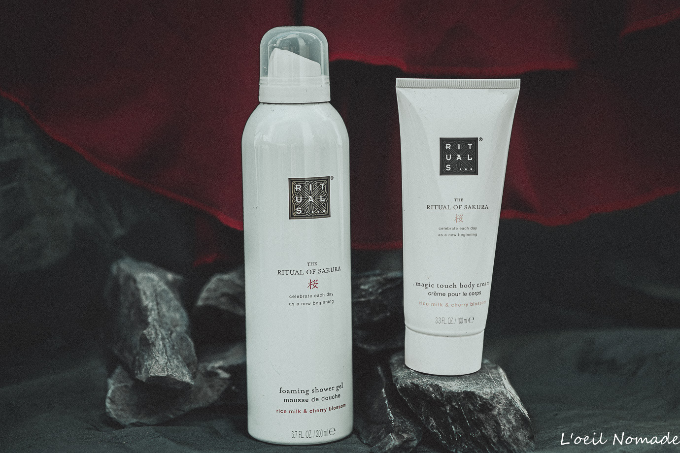 Gamme de soins Rituals sur socle de pierre et tissu drapé, photographie de produit contrastée.