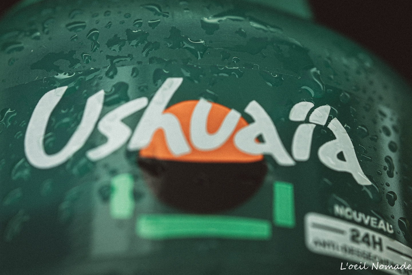 Gros plan sur un gel douche Ushuaïa, style photographique Dark Muted avec éléments végétaux, branding cosmétique naturel.