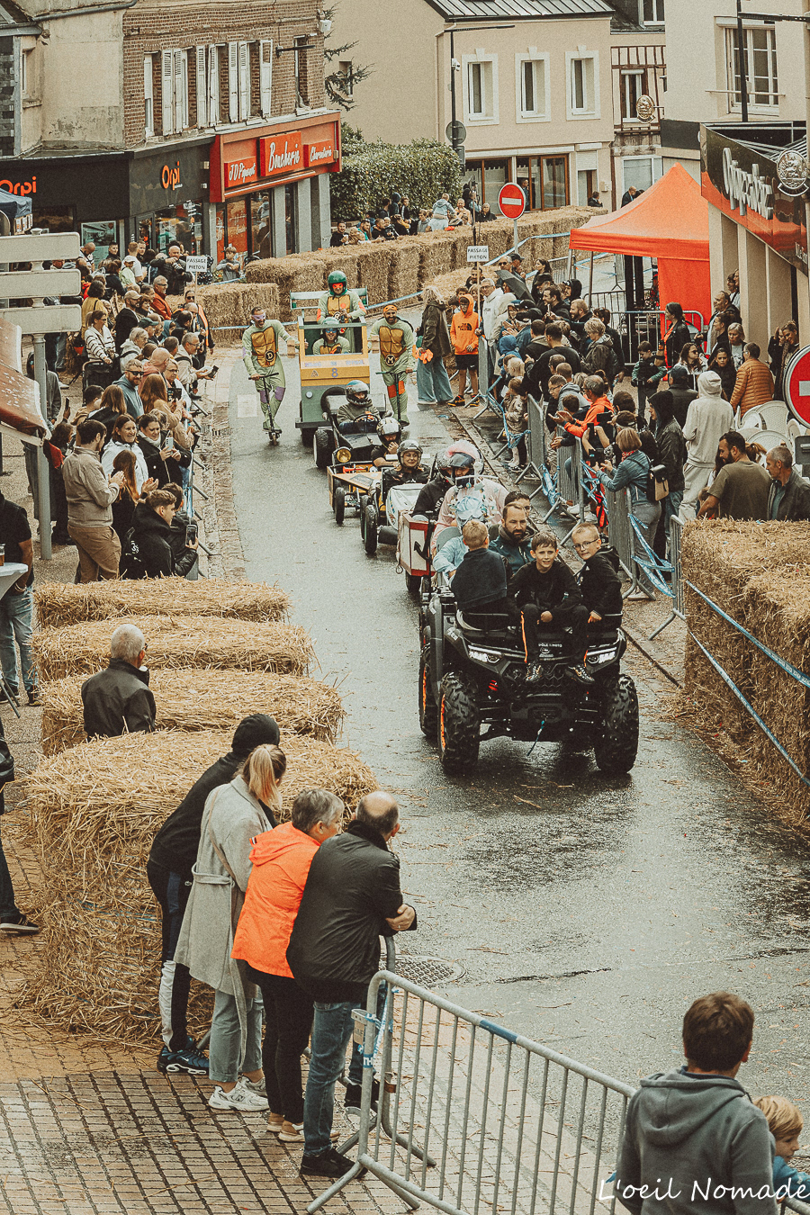 Reportage événementiel au cœur de la course : les caisses à savon dévalant le parcours sécurisé sous le regard des spectateurs.