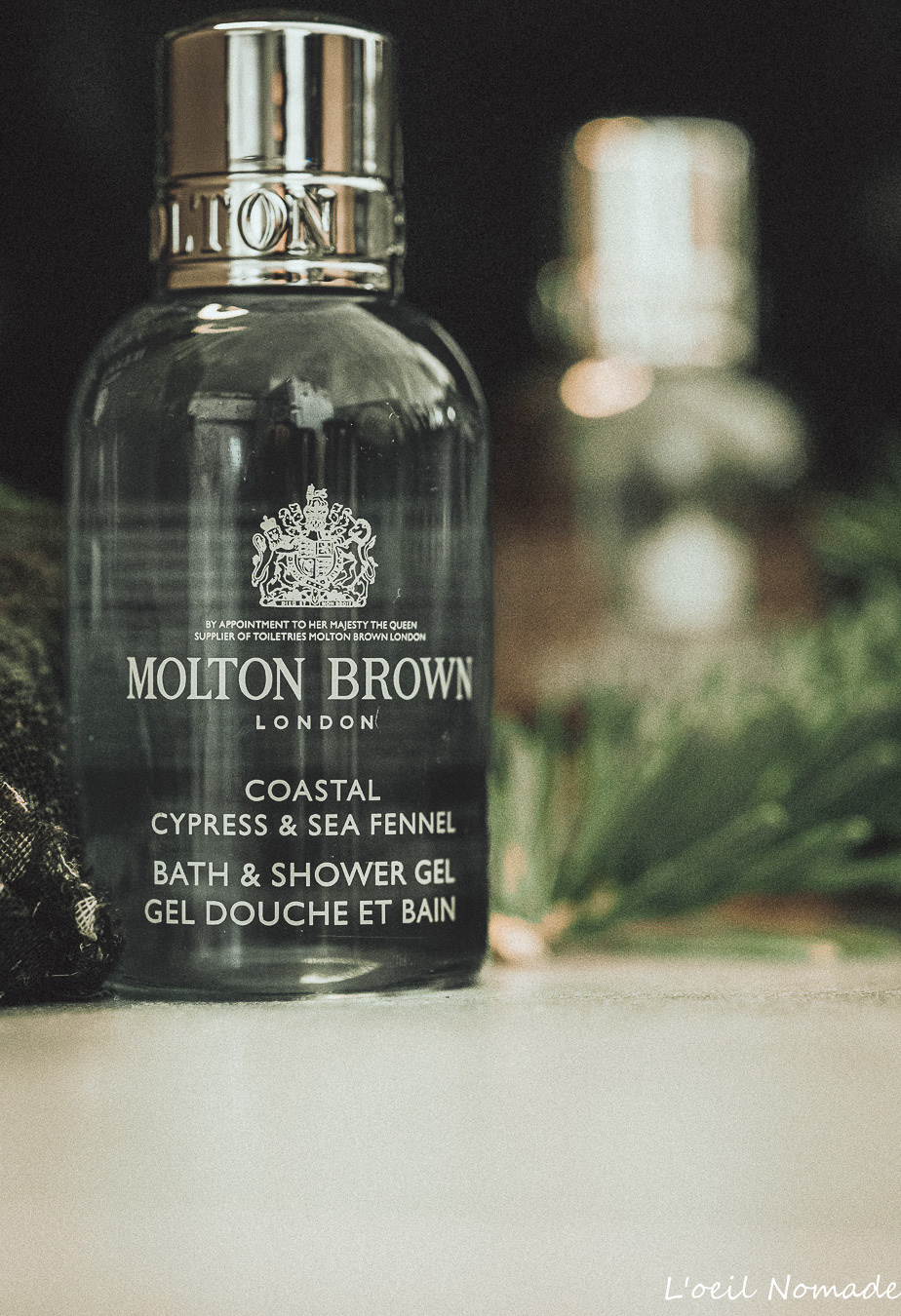 Photographie packshot flacon Molton Brown, mise en valeur du design produit et des textures en lumière naturelle pour marque haut de gamme.