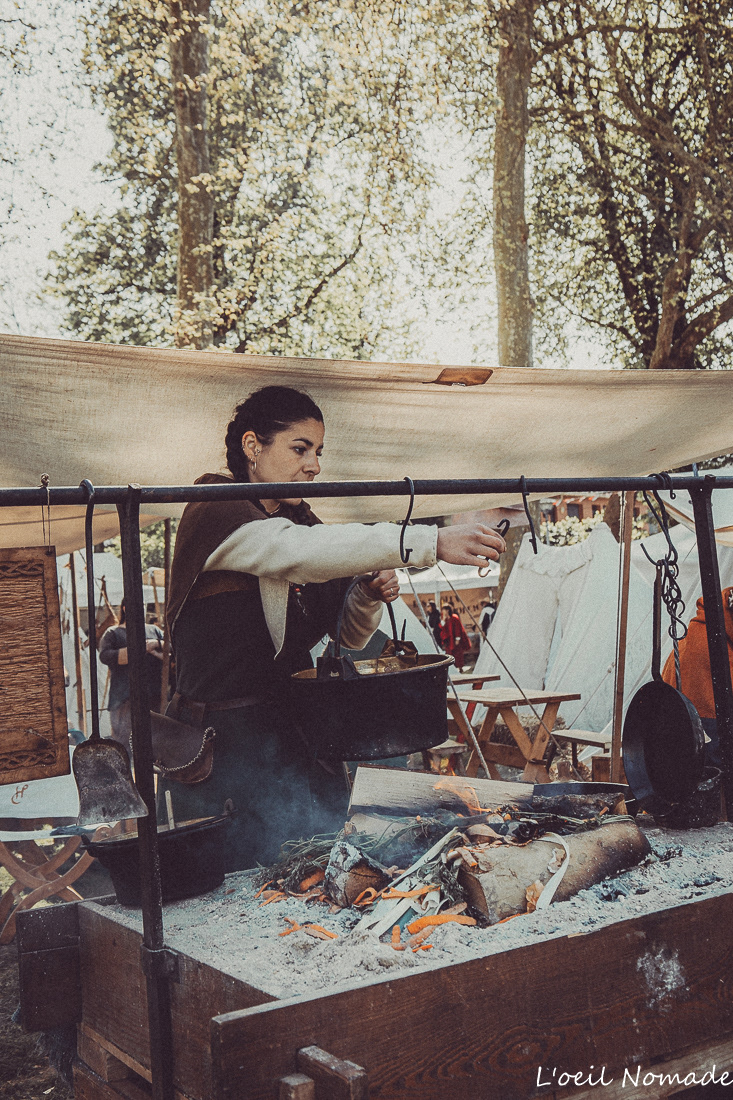 Scène de cuisine médiévale, préparation artisanale en événement historique, reportage authentique.
