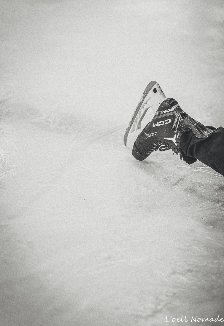 Gros plan sur la lame d'un patin de sport extrême, texture de la glace rayée et reflets.