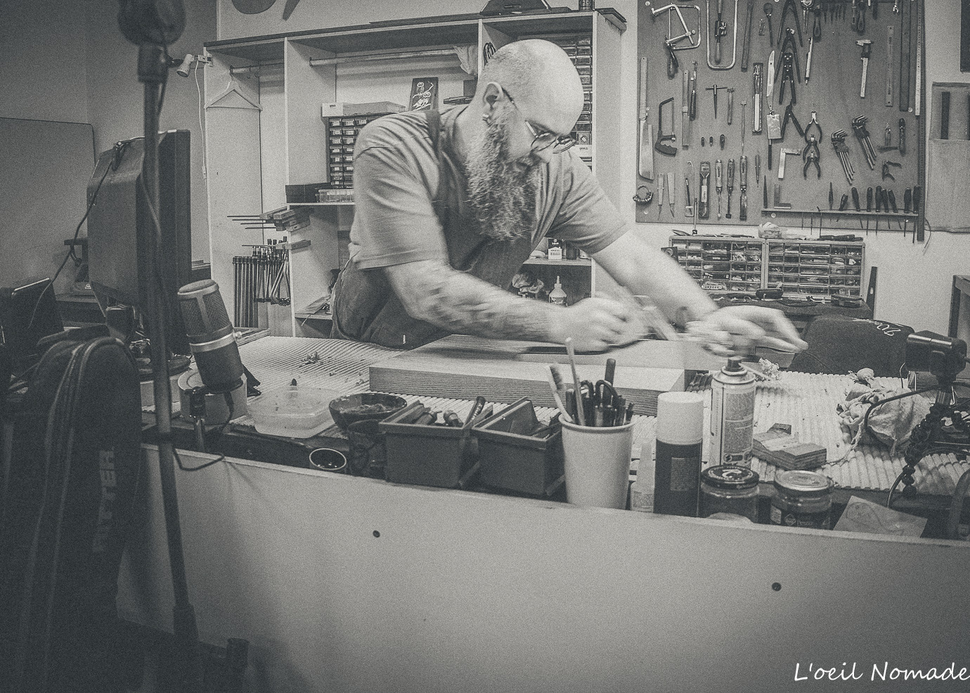 Portrait technique d'un luthier en action dans son atelier, focus sur le geste expert et la matière, photographie Dark Vintage B2B.