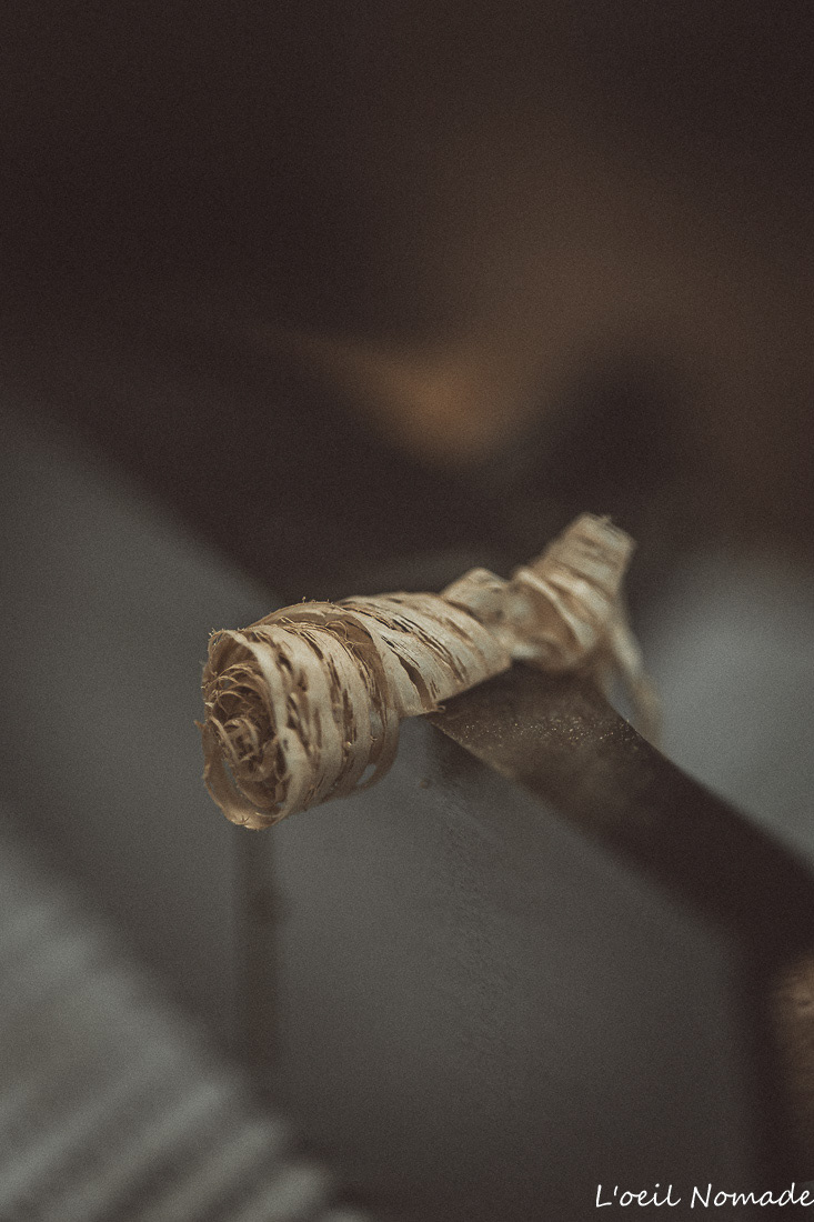 Texture bois brut et copeaux dans l'atelier Wooden Owl, macrophotographie artisanale.