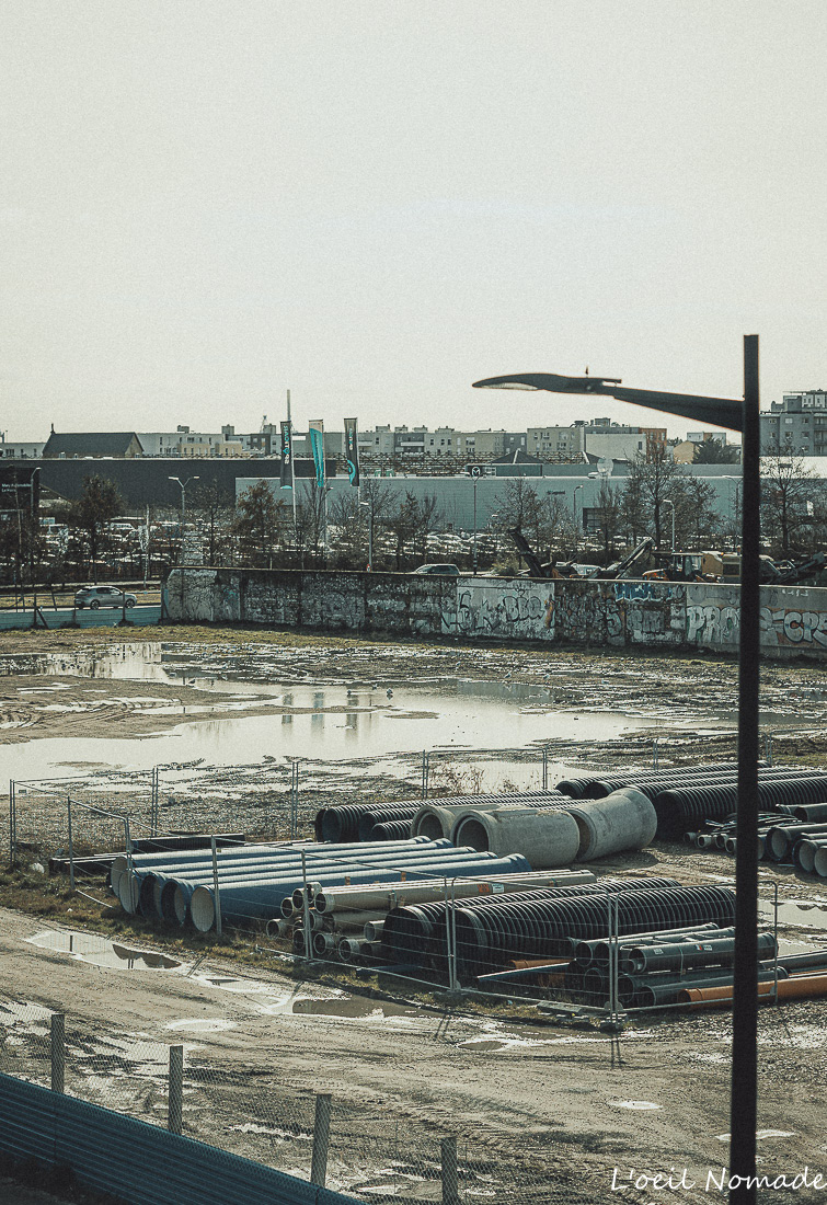 Photographe professionnelle de reportage en action sur un chantier BTP au Havre, style documentaire brut.