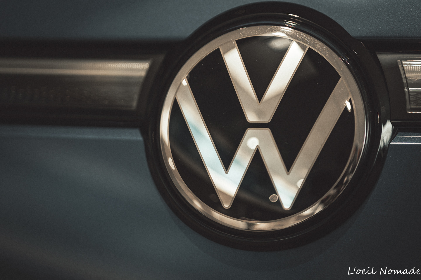 Photographie logo Volkswagen éclairé sur calandre, technologie LED, expertise L’œil Nomade.