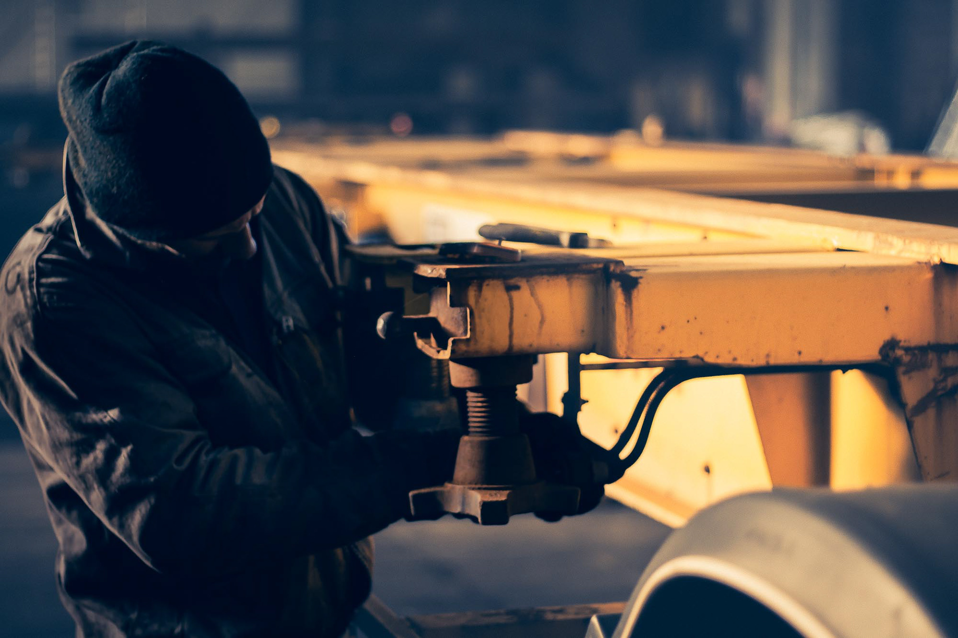 Photographie de métier chez Jeletrans au Havre : mécanicien poids lourd concentré sur son geste technique, documenter l'expertise sans mise en scène.