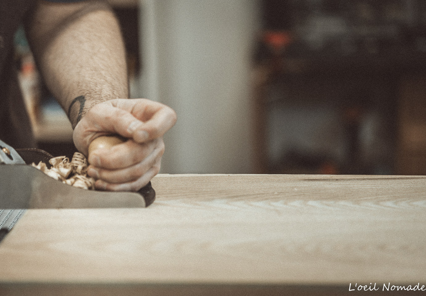 Luthier Wooden Owl utilisant un rabot à main, reportage artisanat Le Havre, focus sur le travail du bois.
