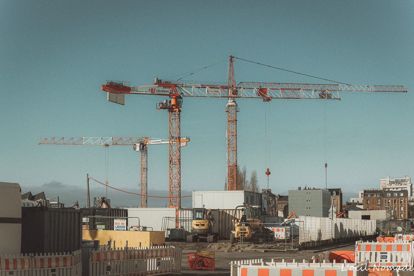 Grues de chantier s'élevant sur un site de construction urbain, reportage sur l'évolution des infrastructures du tramway.