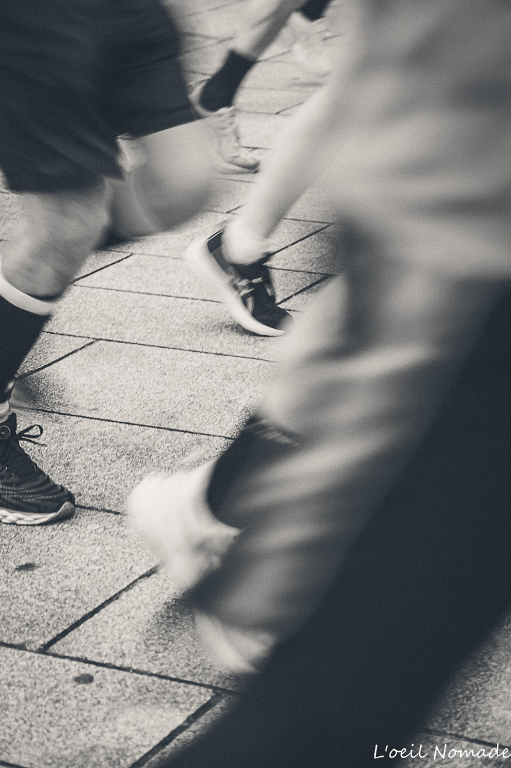 Détail d'un coureur en plein effort, focus sur la détermination, style photographique contrasté.