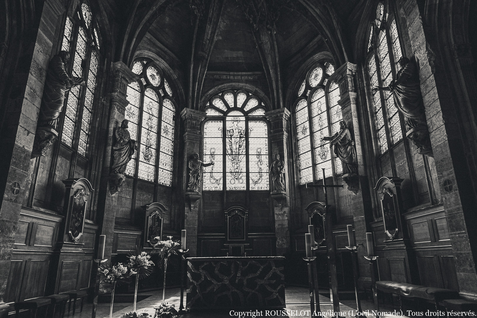 Reportage intérieur : la nef de la Cathédrale Notre-Dame du Havre en noir et blanc, entre ombre et lumière.