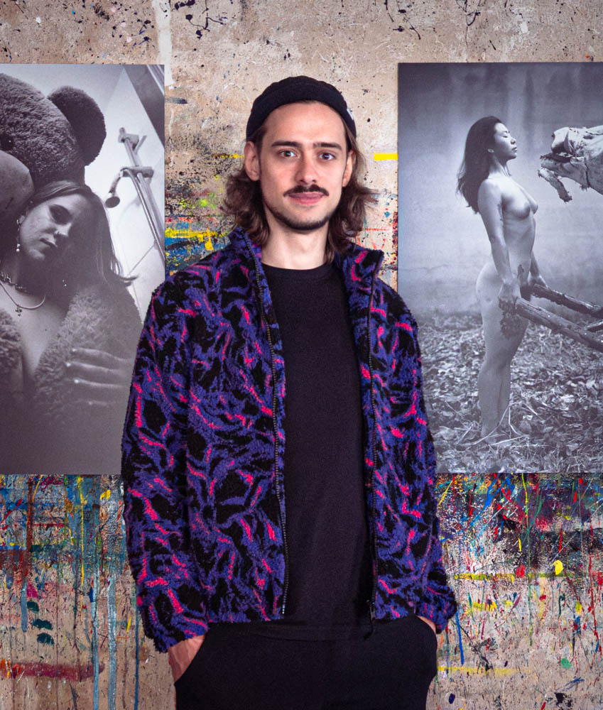 Tobias Ahlbrecht in front of his printed photographs during one of his exhibitions