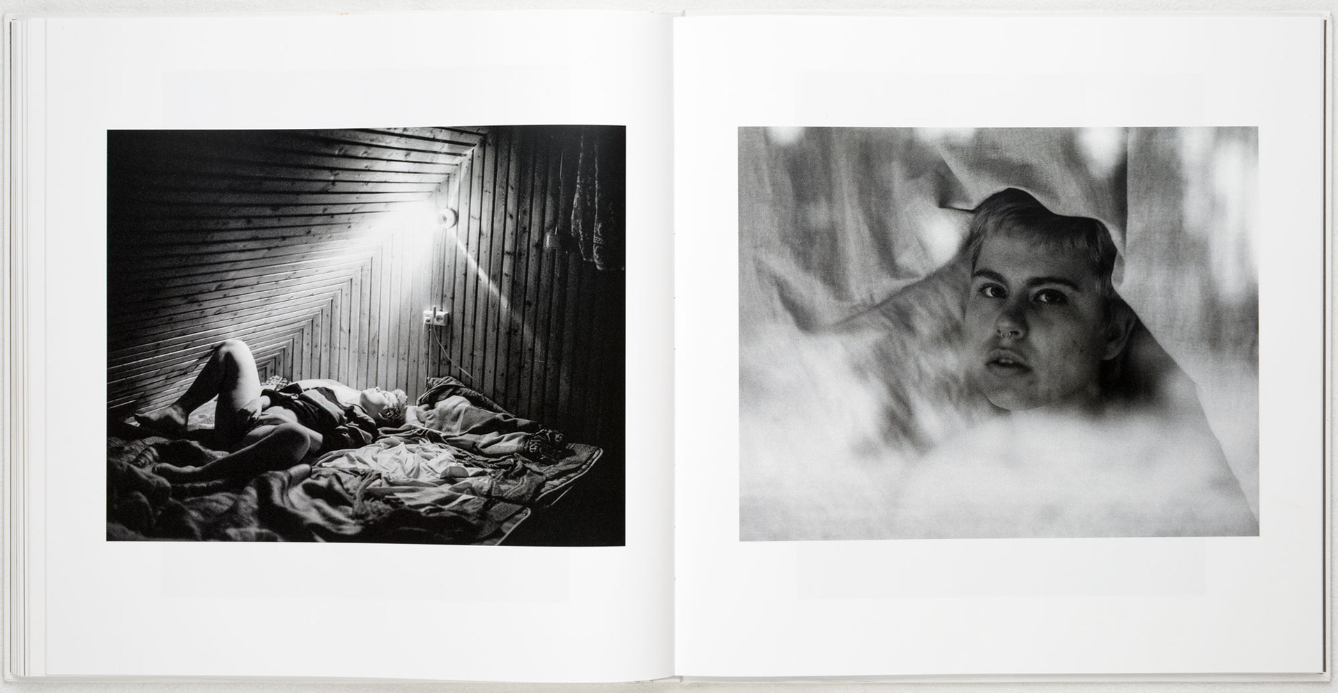 The model Kristina laying in bed and under a curtain, photo by Tobias Ahlbrecht.