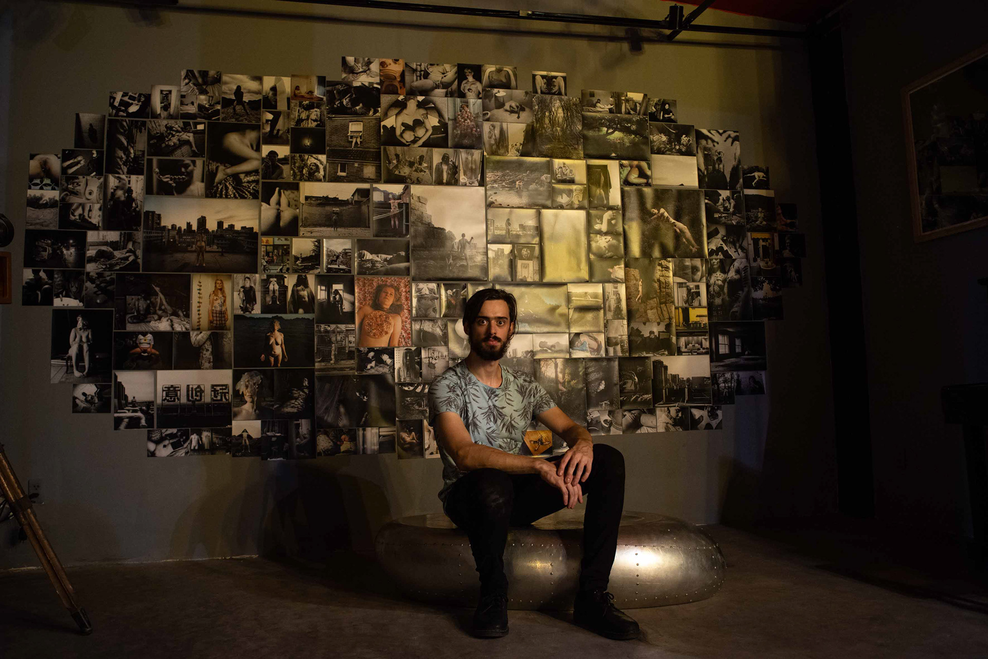Portrait of the fotografer and artist Tobias Ahlbrecht in front of the main photo grid of his 'Return to Nomansland' and 'Nomansland' images.