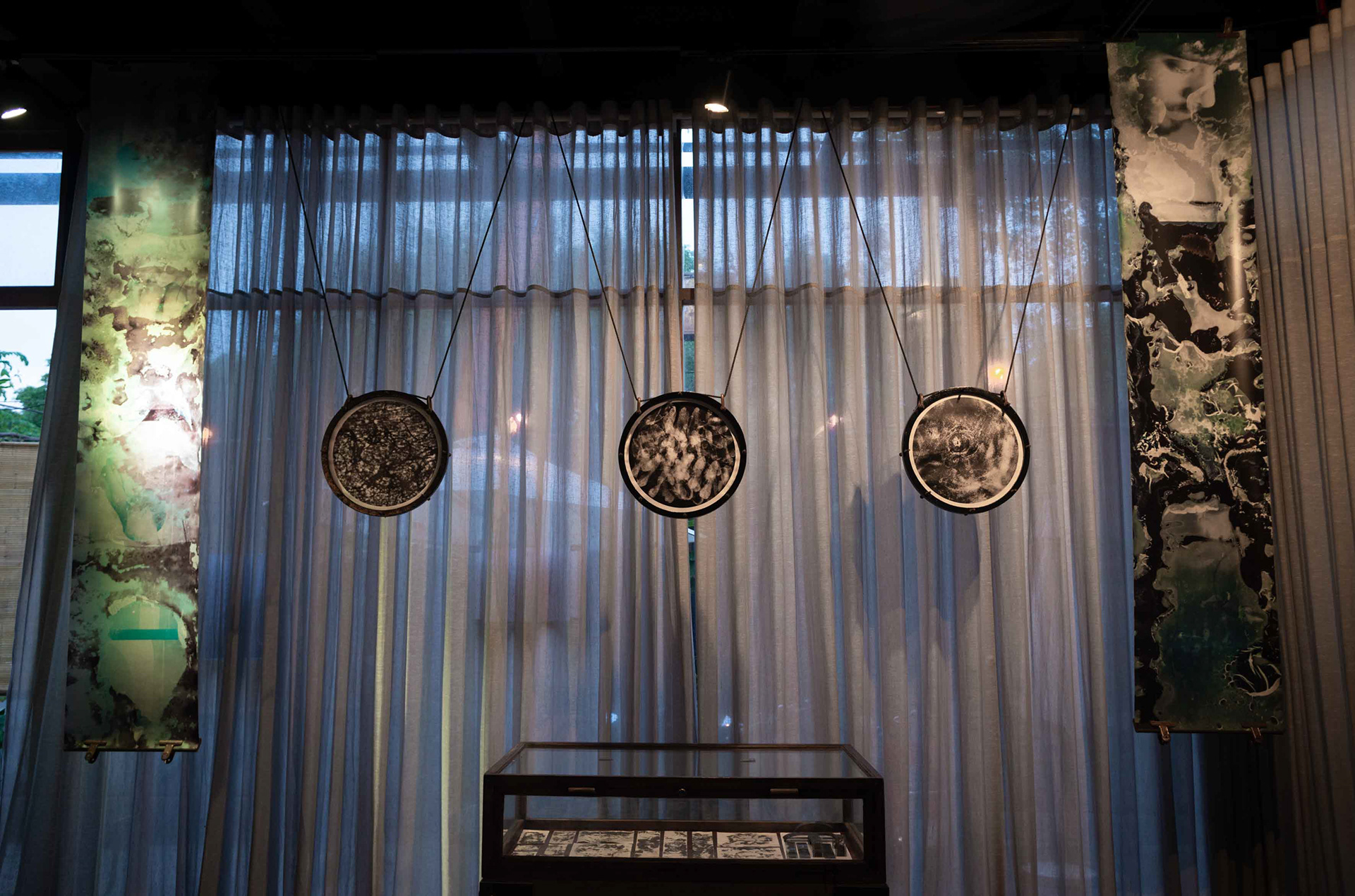 Three handmade photographs in circular wodden black frames by Tobias Ahlbrecht from his 'One' series as shown in Saigon, Vietnam.